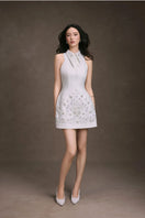 Keira Tong Flora embroidered mini dress with floral patterns, fitted waist, and short sleeves, displayed on a hanger.