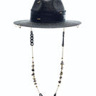 Black fedora hat by LE SH KA featuring shells and 24k gold-plated accessories, stylish headwear with decorative embellishments.