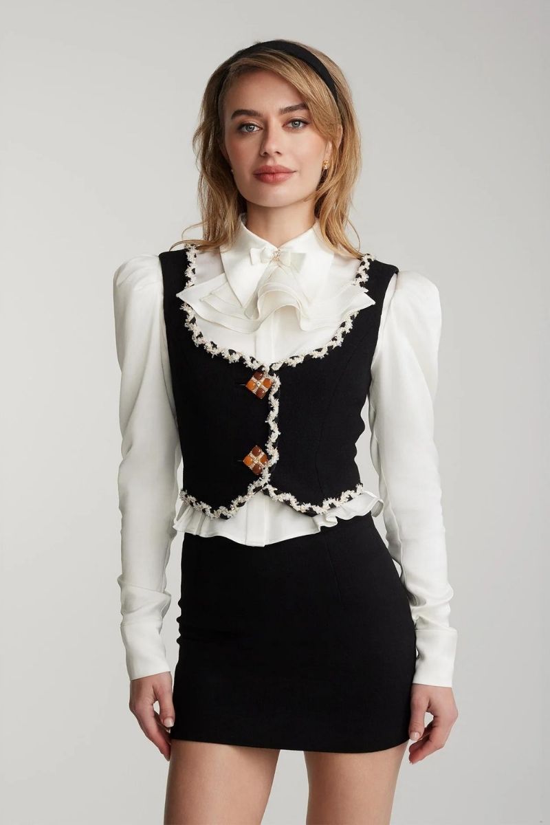 Nana Jacqueline Lisette black mini skirt made of sleek fabric, shown on a model with a close-up of the skirt's fitted waistband.
