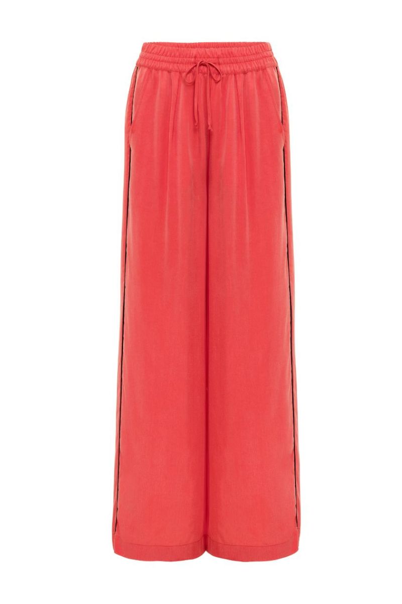 niLuu AQUAFLORA lounge pants in coral, lightweight and comfortable pants with a relaxed fit, shown on a model.