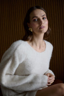 Undress Alexa Cream Mini Sweater Dress, close-up of the soft, cream-colored knit fabric and fitted silhouette on a mannequin.