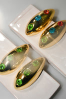 Liya Ocean Eye Green Earrings featuring vibrant green gemstone dangles and silver hooks on a plain background.