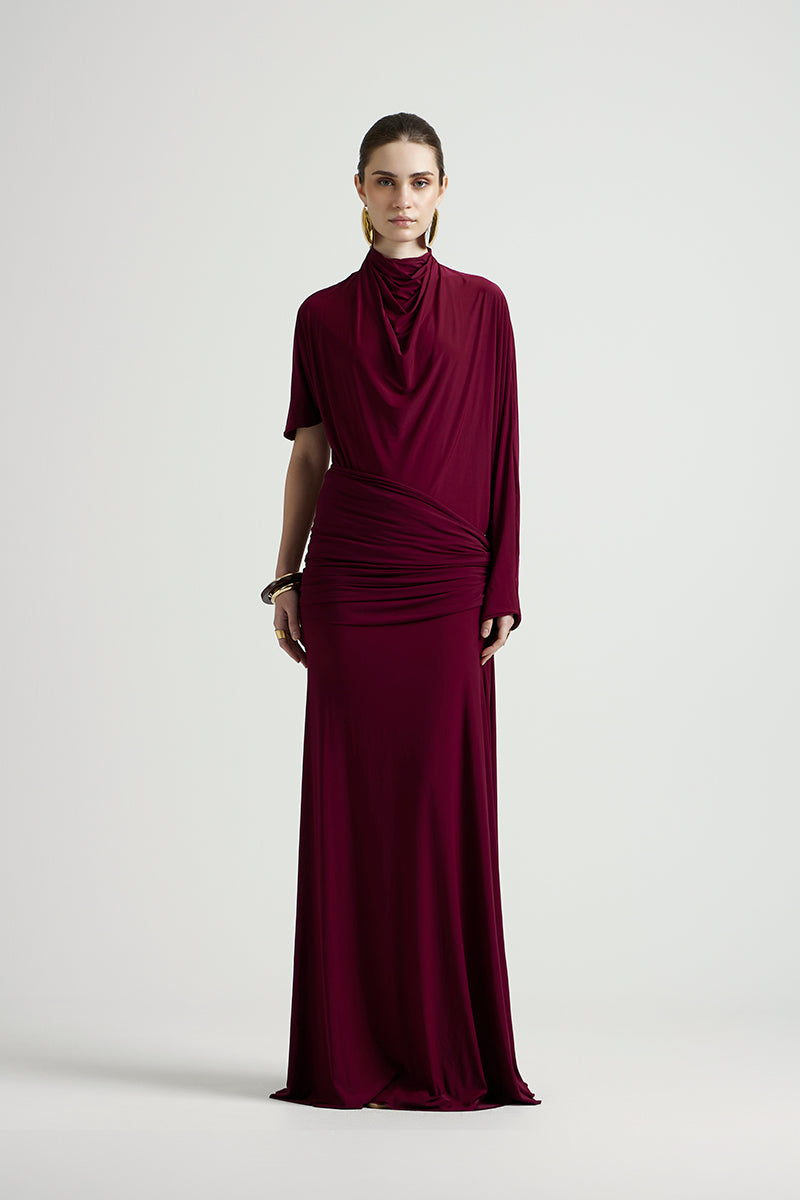 Deme By Gabriella Lorraine maxi dress in aubergine, flowing fabric with elegant design and long sleeves, displayed on a hanger.