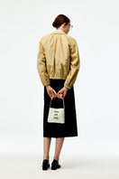 Beige cotton bomber jacket by Chictopia, featuring a classic design with ribbed cuffs and collar, displayed on a hanger.