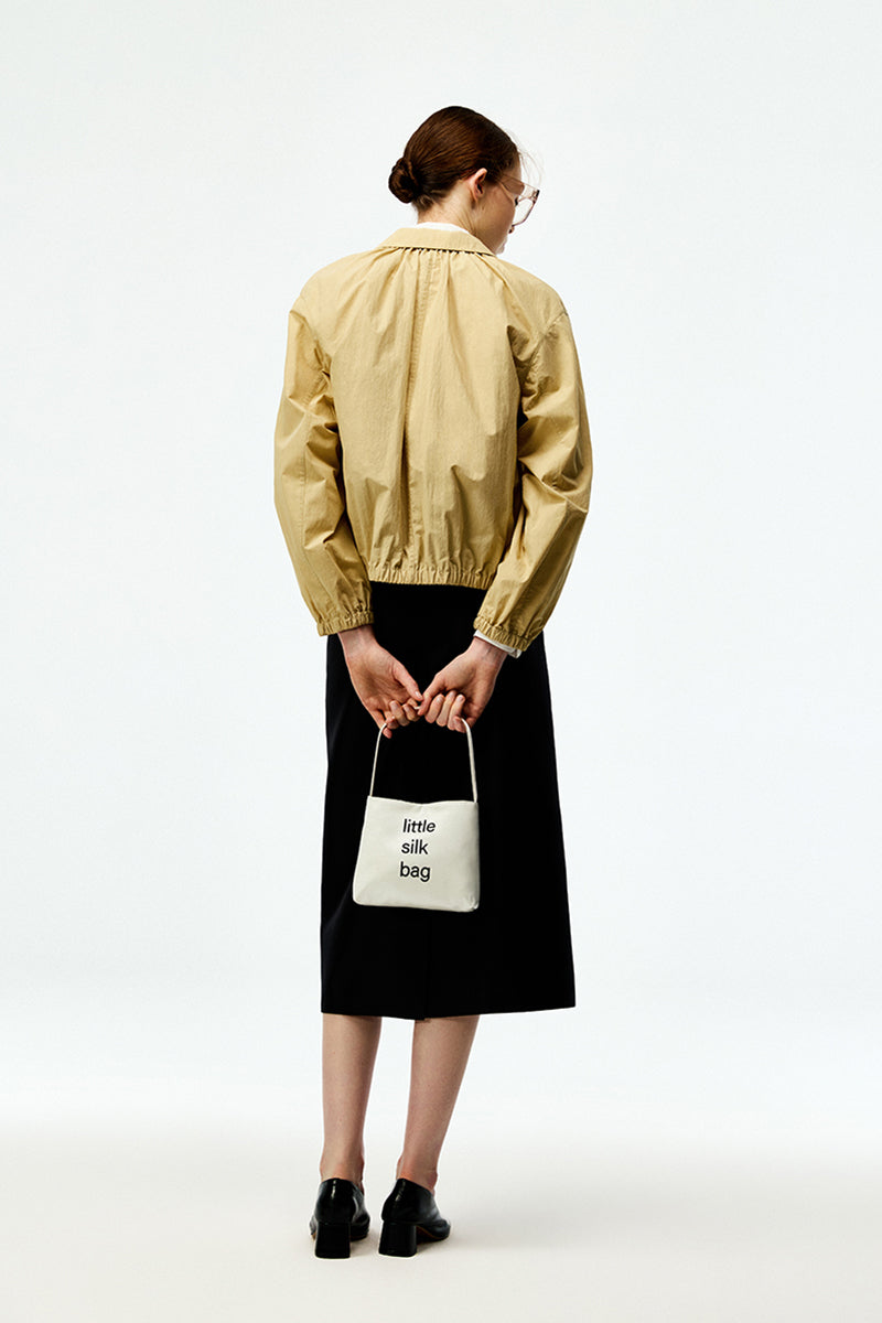 Beige cotton bomber jacket by Chictopia, featuring a classic design with ribbed cuffs and collar, displayed on a hanger.