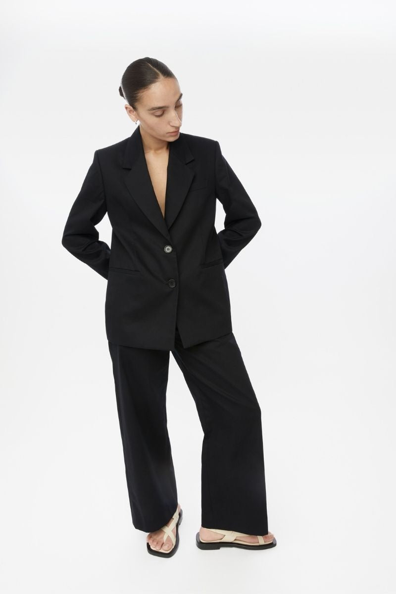 Dāl the Label cotton twill blazer in neutral color, tailored fit with lapel collar and front button closure, styled on a mannequin.