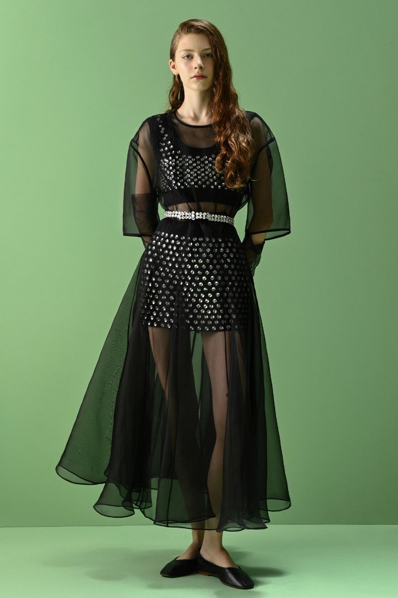 Black Lalo Thalia mini skirt displayed on a hanger, showcasing its slim fit and stylish design.