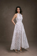 Keira Tong floral lace maxi dress displayed on a hanger, showcasing intricate lace details and flowing fabric.