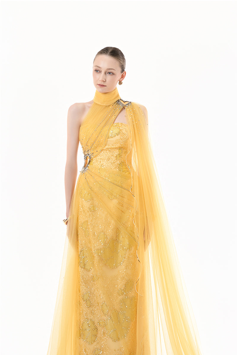 Golden yellow embellished tulle cape gown by Happy Clothing, featuring intricate embroidery and flowing fabric, perfect for elegant occasions.