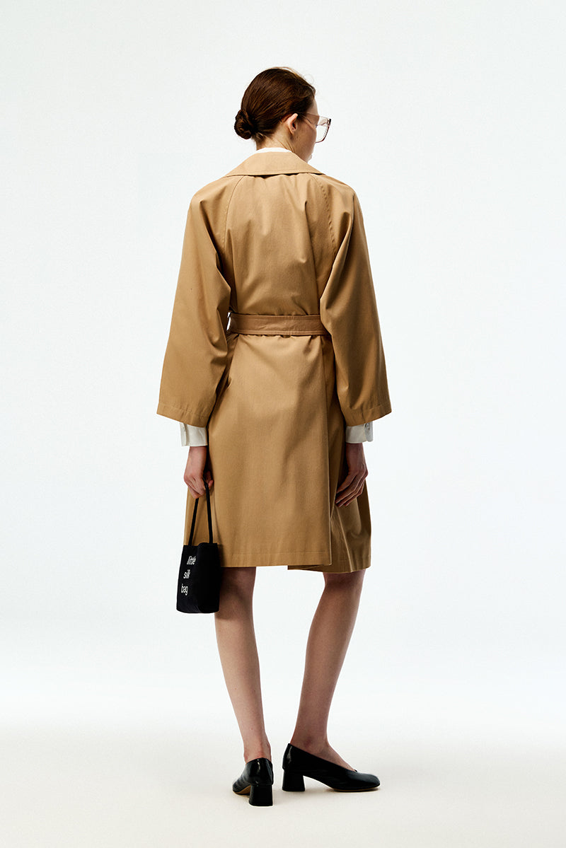 Beige cotton trench coat by Chictopia, featuring classic double-breasted design and belt, displayed on a hanger.