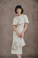 White Plan ivory pearl cape midi dress displayed on a model, featuring elegant pearl embellishments and a flowing silhouette.
