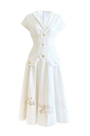 White sleeveless shirt and orchid-flowered midi dress by Do Long, displayed on a mannequin, showcasing casual and elegant summer fashion.