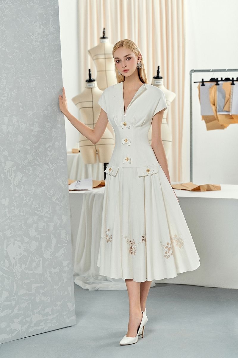 White sleeveless shirt and orchid floral flared midi dress by Do Long, displayed on a model against a neutral background.