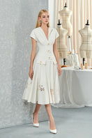 White sleeveless shirt and orchid floral flared midi dress by Do Long, styled together on a model.