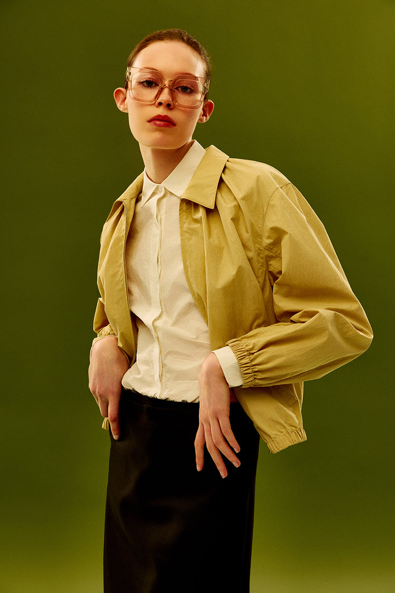 Beige cotton bomber jacket by Chictopia, featuring a stylish fit with ribbed cuffs and collar, displayed on a hanger.