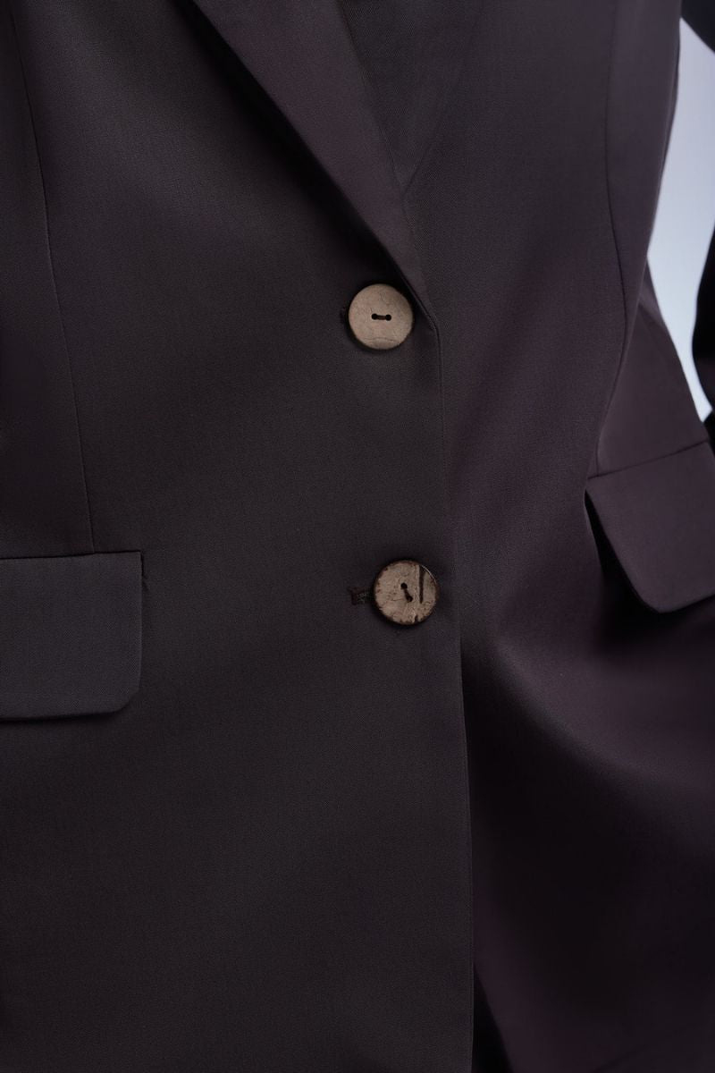 Dāl the Label relaxed single-breasted blazer in neutral fabric, styled for a casual yet polished look.