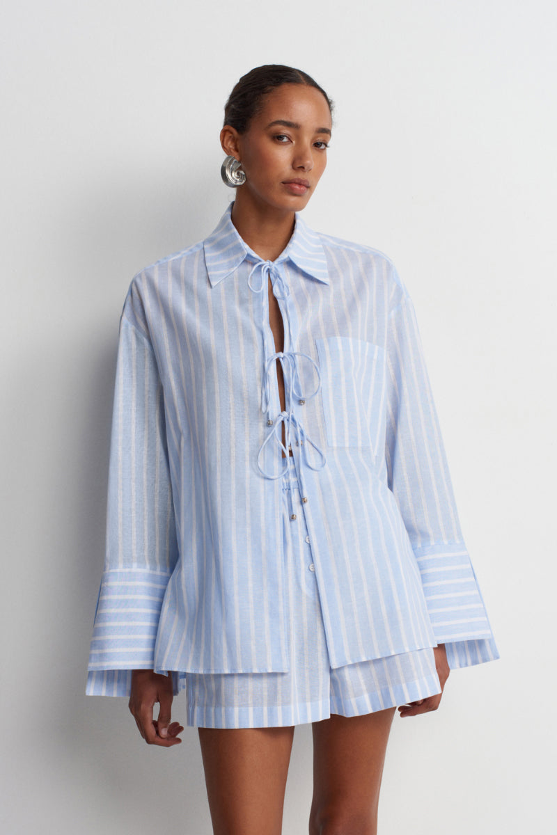 Blue striped Sicilia linen shirt by Acaria Studio, featuring a relaxed fit and casual style for warm-weather wear.