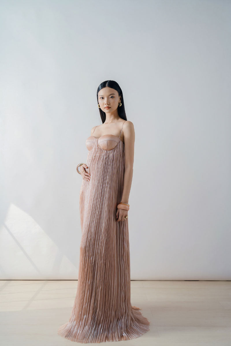 Elegant DOC BAN champagne pleated bustier maxi dress with a fitted column silhouette and flowing skirt, perfect for formal occasions.