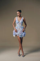 Keira Tong coral V-neck mini dress displayed on a hanger with a flowy, lightweight fabric and short sleeves.