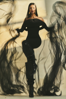 L'SCARLETT form-fitting off-shoulder long-sleeve poly crepe jumpsuit displayed on a model, showcasing its sleek design.