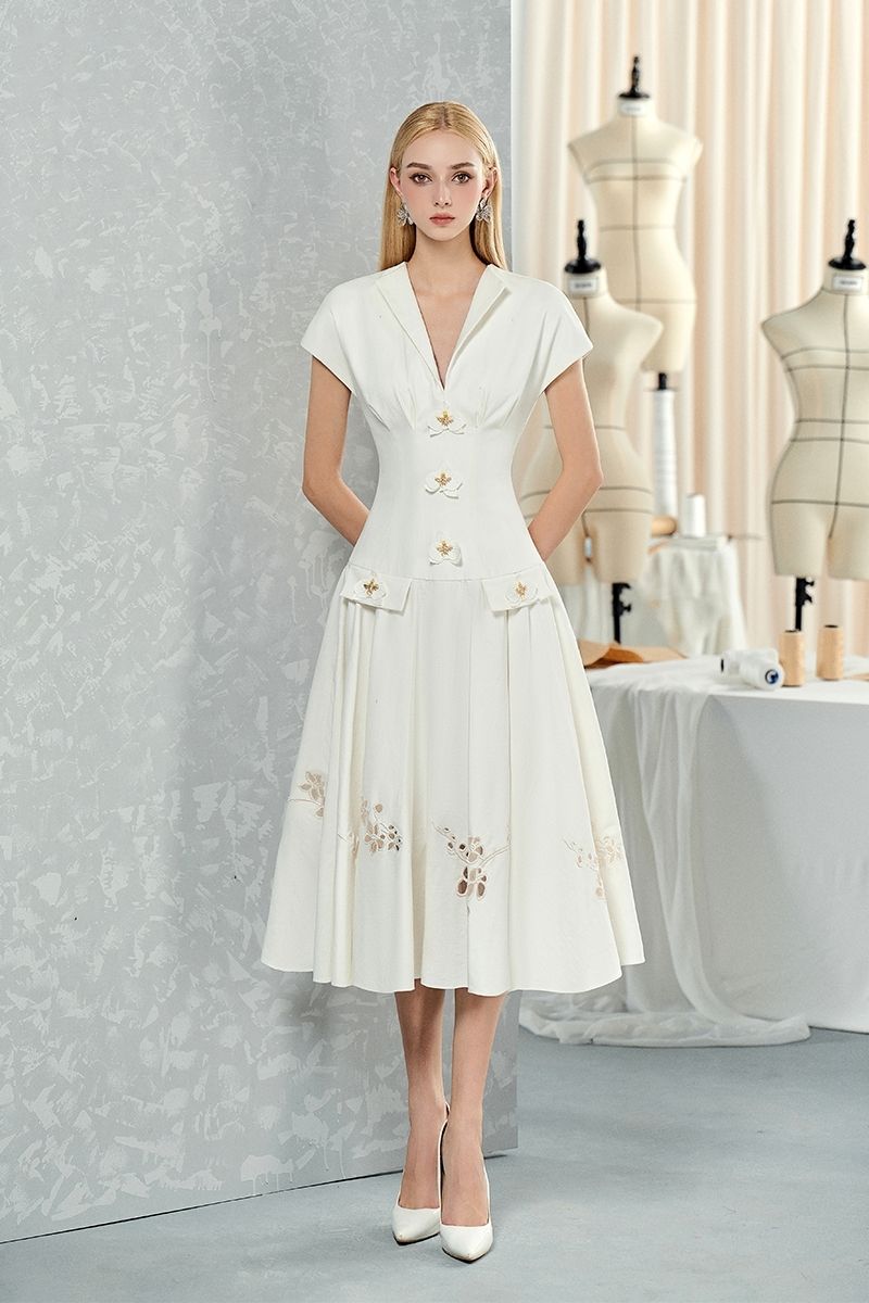 White sleeveless shirt and orchid-flowered flared midi dress by Do Long, displayed together in a fashion image.