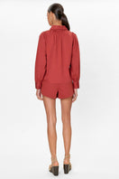 Rebecca Taylor Rachelle pop-over blouse in burnt sienna, featuring a relaxed fit and lightweight fabric, displayed on a hanger.