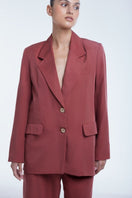 Dāl the Label relaxed single-breasted blazer in neutral fabric, tailored fit, displayed on a hanger against a plain background.