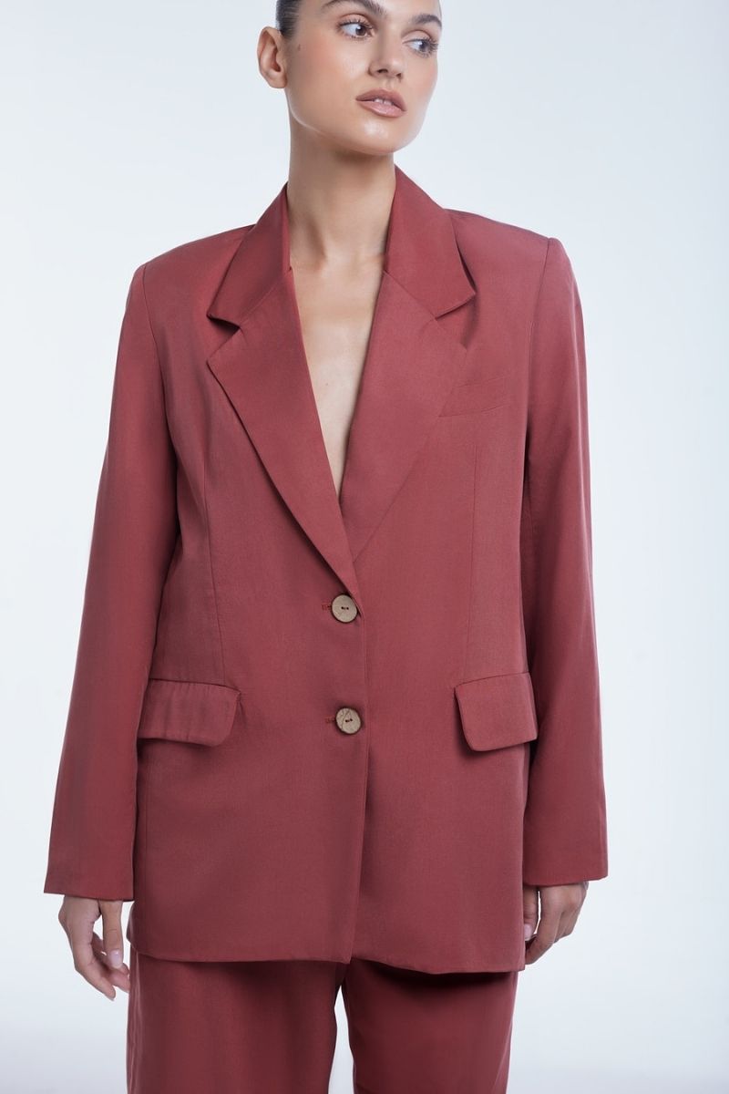 Dāl the Label relaxed single-breasted blazer in neutral fabric, tailored fit, displayed on a hanger against a plain background.