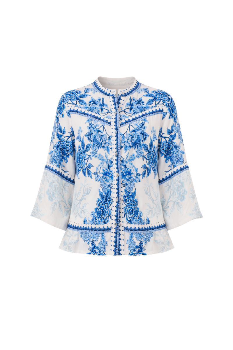 Raishma Myra shirt displayed on a hanger, featuring a stylish design with fabric details and a classic fit.