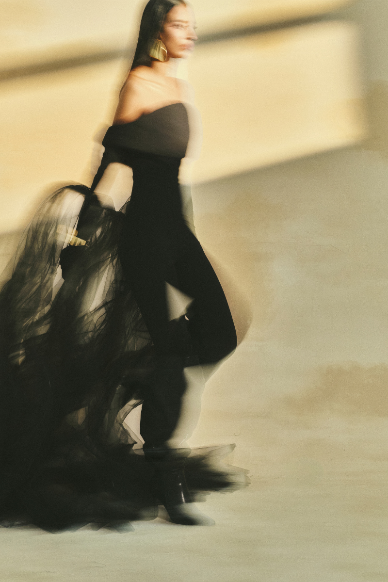 L'SCARLETT form-fitting off-shoulder long-sleeve poly crepe jumpsuit displayed on a model.