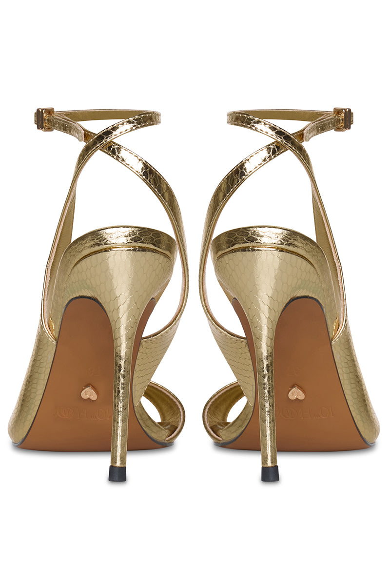 Gold high heels from 10th Floor's Midnights Heel collection, featuring elegant stiletto design and stylish ankle strap.