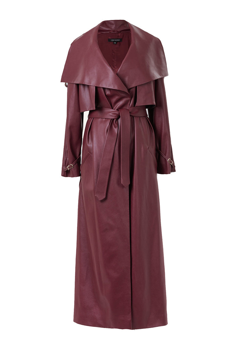 Vegan leather maxi trench coat with buckles in burgundy by Kris Marán, stylish long coat with buckle details and classic design.