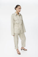 Dāl the Label canvas cotton jacket with front pockets and button closure, displayed on a hanger.