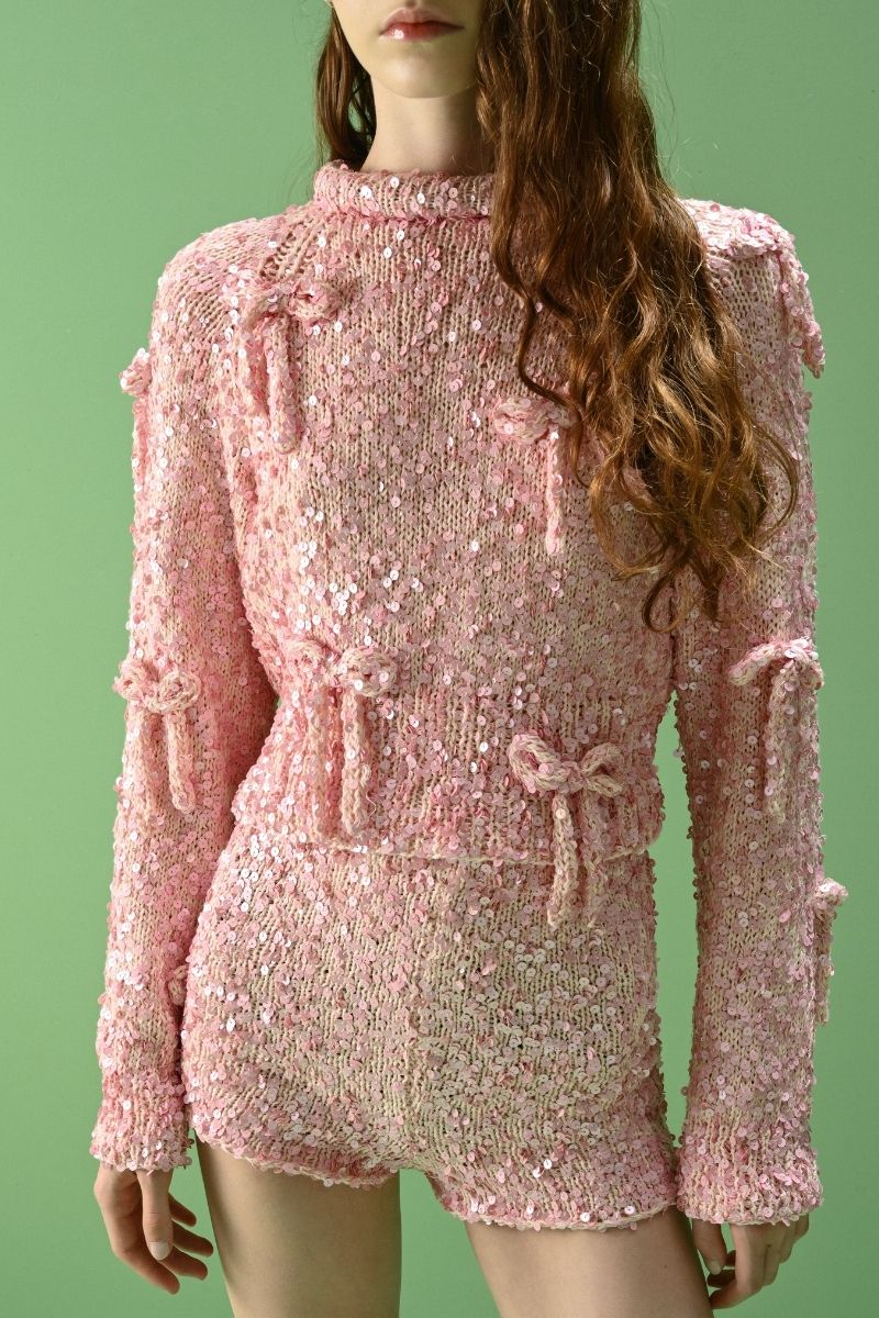 Lalo Salue long sleeve sweater in pink, soft knit fabric, shown on a model, featuring a relaxed fit and ribbed cuffs.