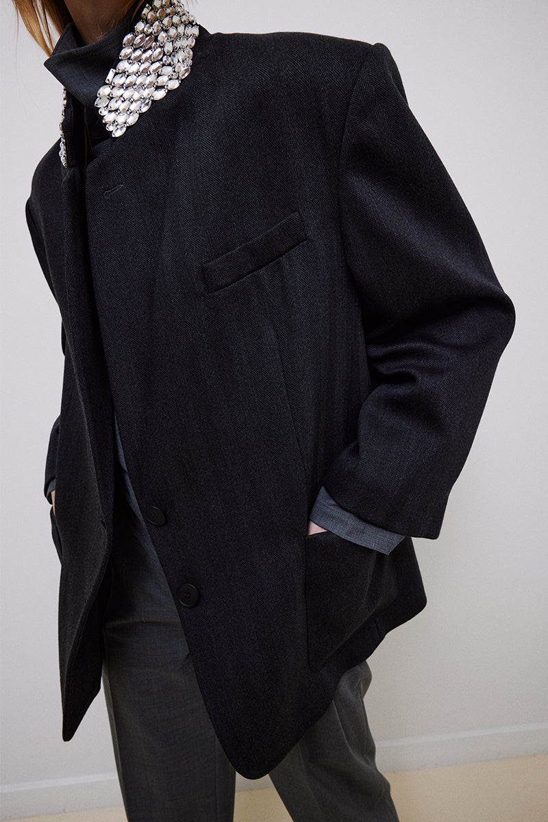 Gray oversized jacket with hand-embellished collar by TAGG, featuring unique decorative details and a relaxed fit.