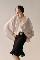 Black LeCia trumpet skirt in midi length, shown draped elegantly on a model with a fitted waist and flared hem.