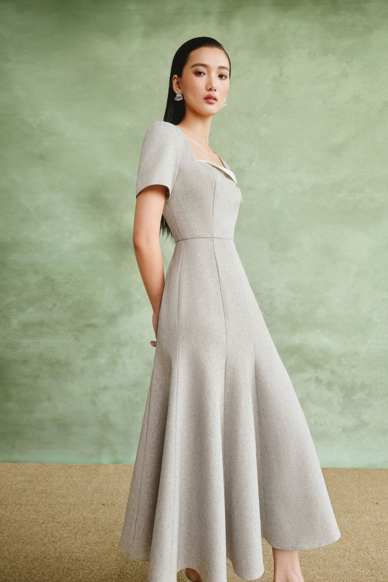White Plan minimalist square-neck midi dress displayed on a hanger, showcasing its sleek design and clean lines.