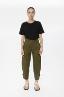 Light beige Dāl the Label canvas cotton pants with a relaxed fit and side pockets, displayed on a hanger.