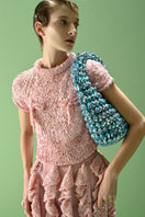 Lalo SALUE mini pink midi skirt displayed on a hanger, showcasing the soft fabric and stylish design.