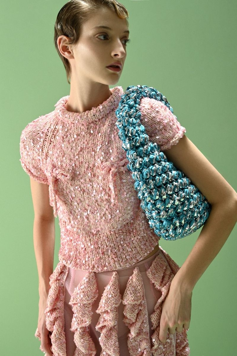 Lalo SALUE mini pink midi skirt displayed on a hanger, showcasing the soft fabric and stylish design.