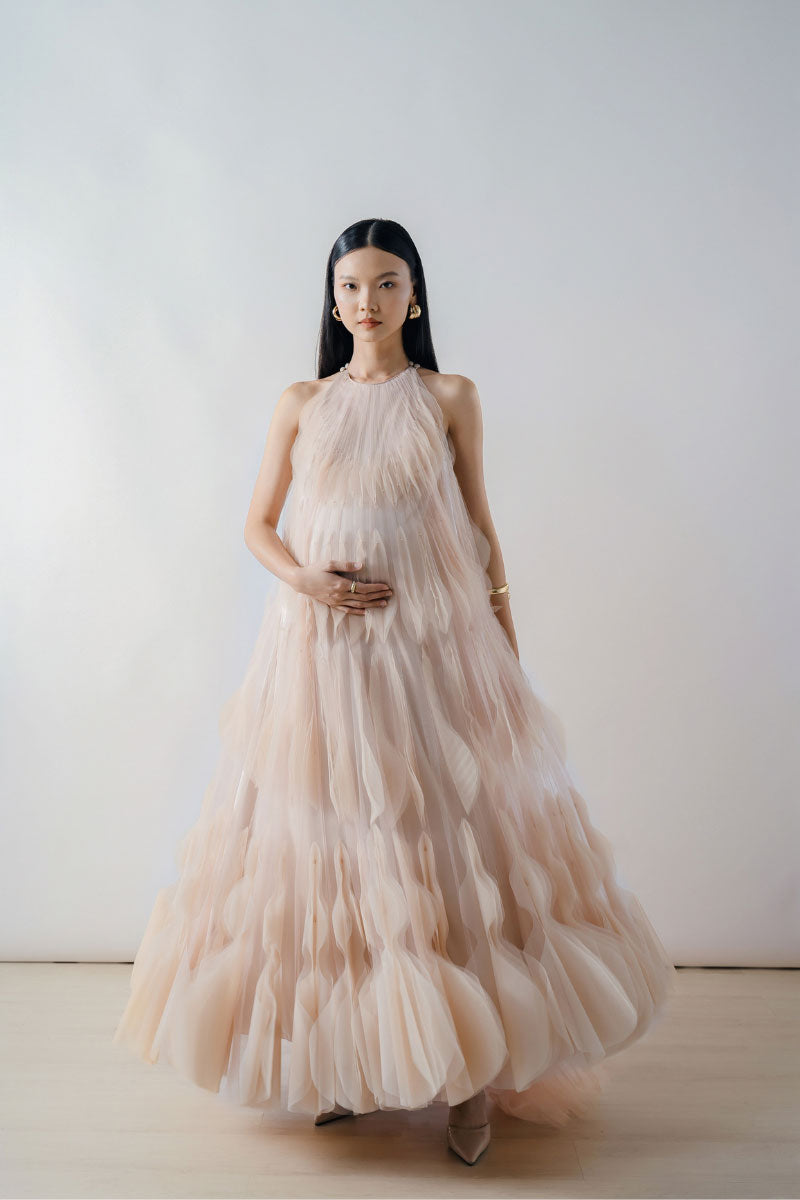 Beige halter neck tiered pleated tulle maxi dress by DOC BAN, showing flowing fabric and elegant silhouette.