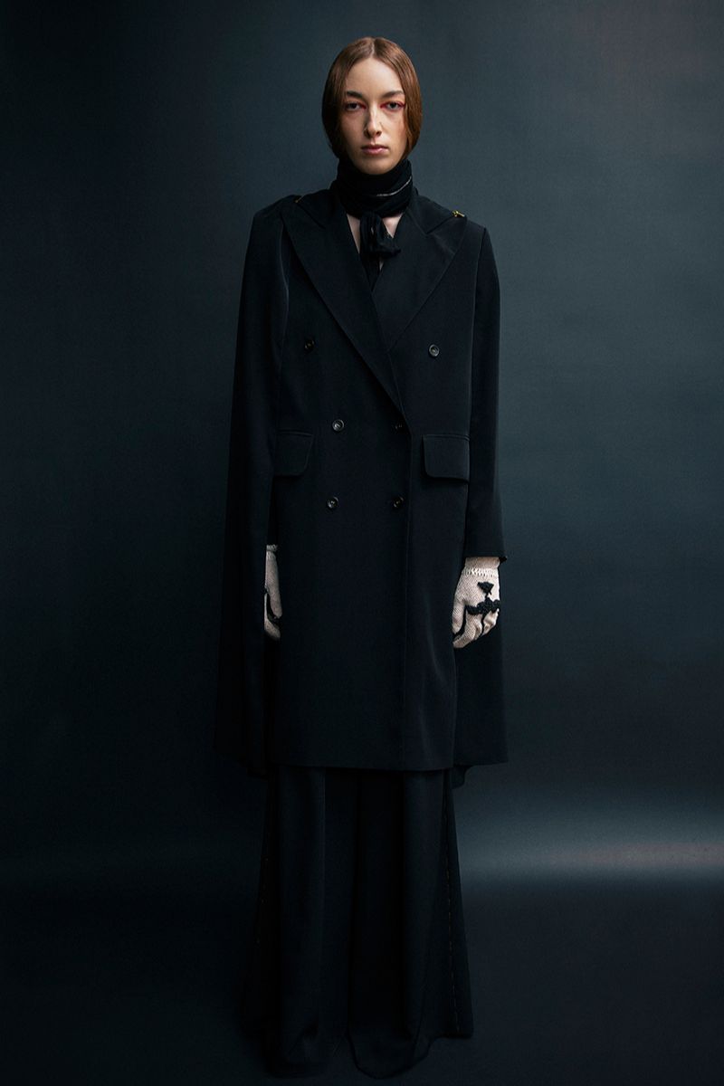 Black Vaska long coat with zip-on detachable scarf, stylish and warm outerwear, shown on a model.