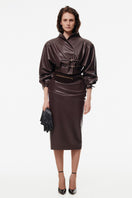Brown sculpted midi skirt with pleat detailing by Kris Marán, featuring a tailored fit and stylish design.