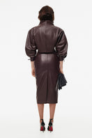 Brown Kris Marán sculpted midi skirt with elegant pleat details, showcasing a fitted silhouette and stylish design.