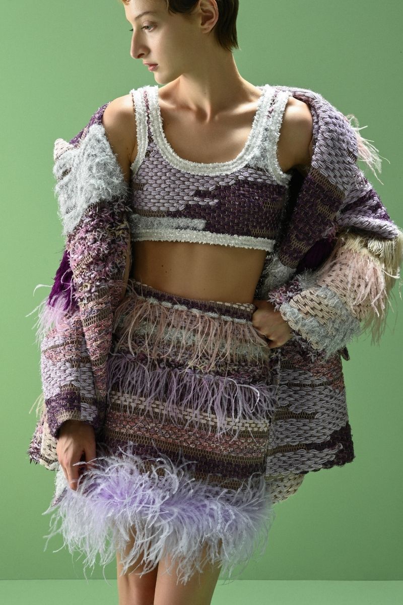 Lalo Avril mini skirt in purple multi with colorful pattern, made from lightweight fabric, displayed on a hanger.