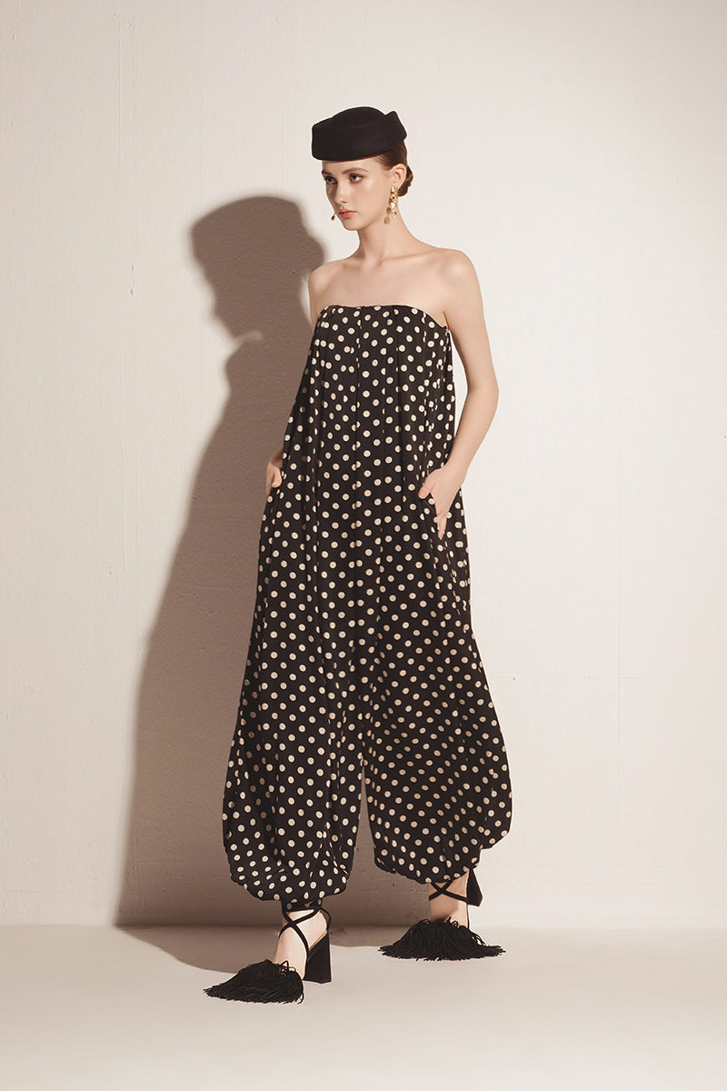 Black Valenciani jumpsuit shown on a hanger with a fitted silhouette and sleek design.