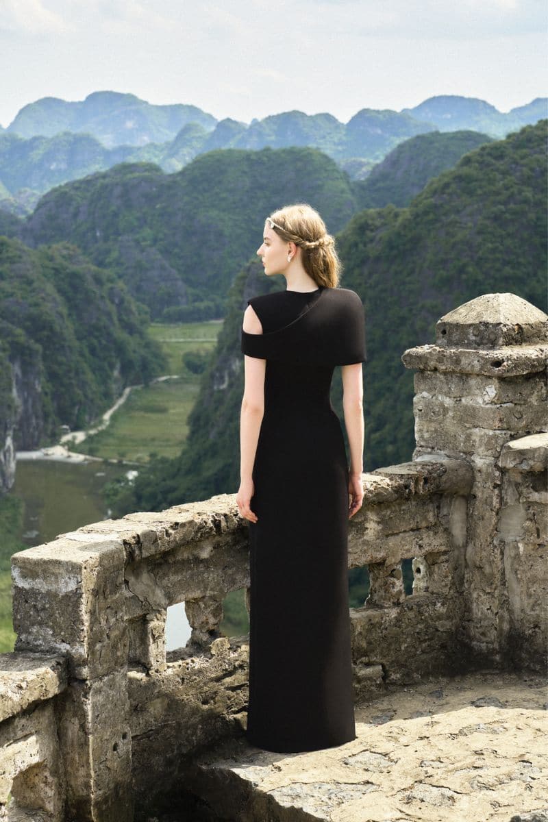 Black stone orchid asymmetric shoulder gown with matching cape by Tracy Studio, featuring elegant draped fabric and intricate detailing.