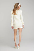 Nana Jacqueline Lisette white mini skirt featuring a fitted waist and short length, styled with casual summer look.