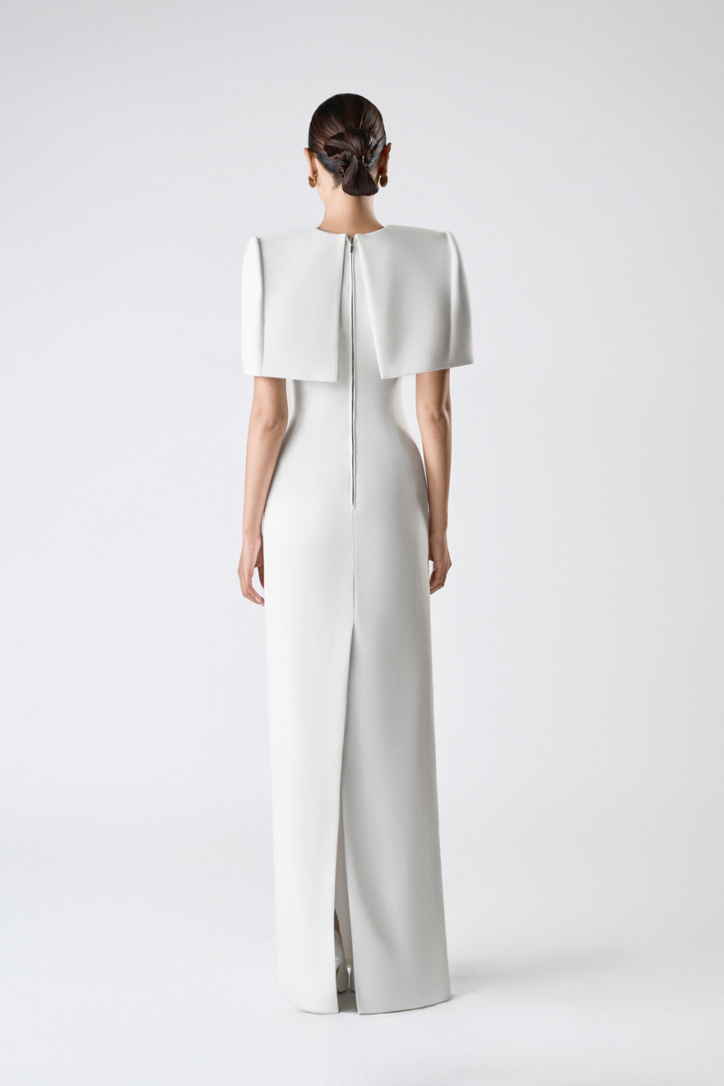 Elegant SILKEN WHISPER GOWN by TONYY, featuring flowing fabric and intricate design, displayed on a mannequin.