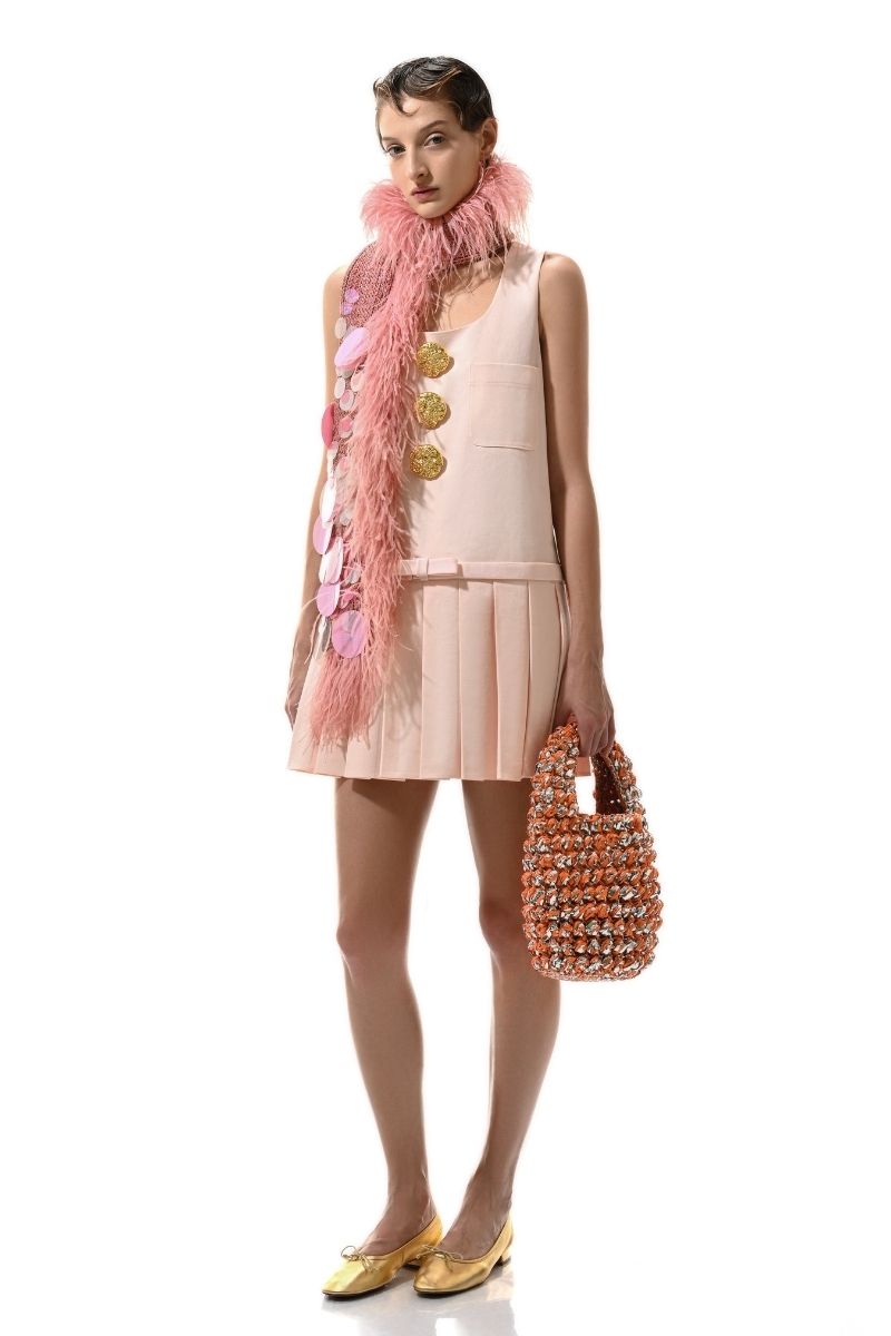 Hand knitted pink embellished scarf by Lalo, showcasing intricate details and soft texture in a close-up image.
